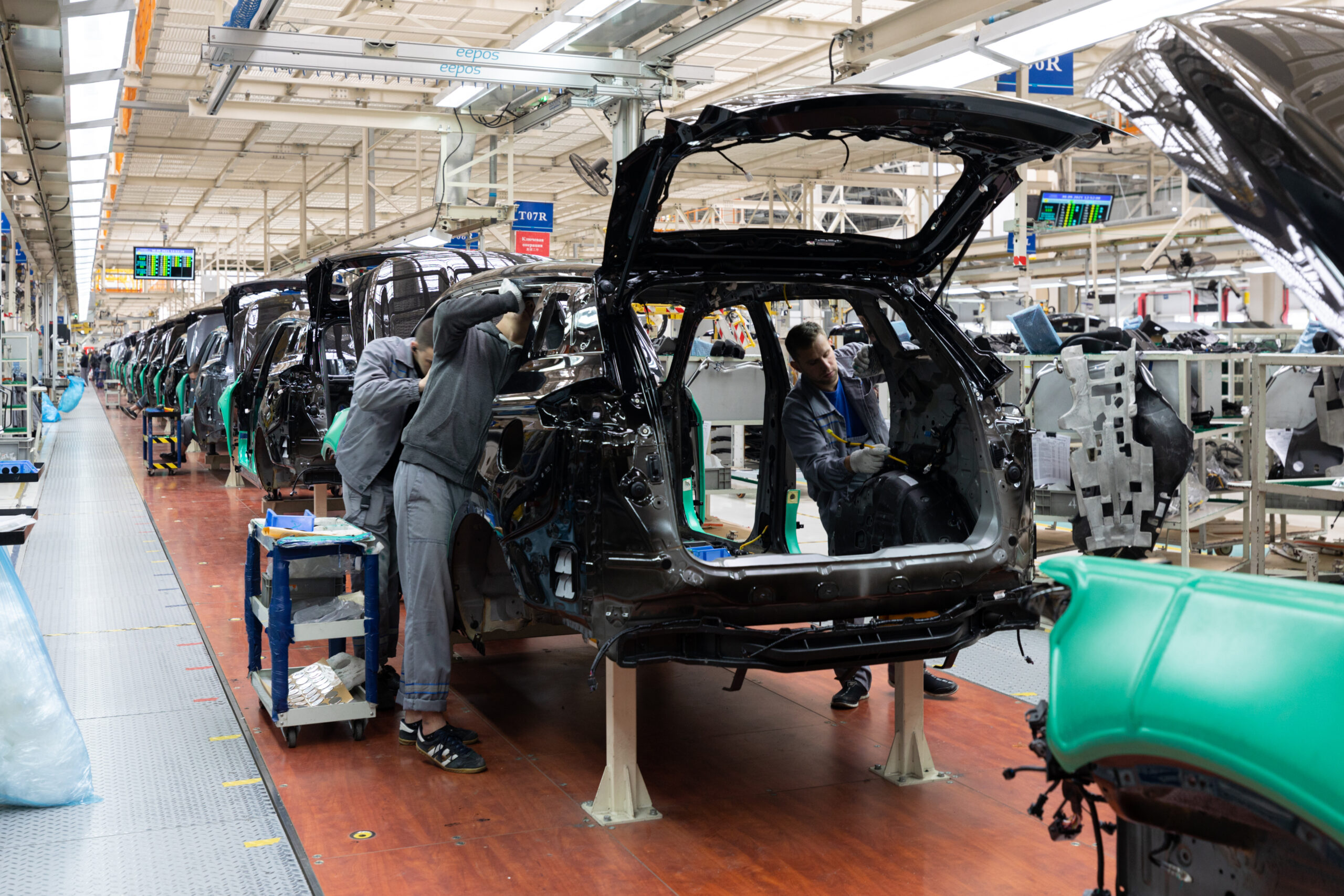 Car bodies are on assembly line. Factory for production of cars. Modern automotive industry. A car being checked before being painted in a high-tech enterprise.